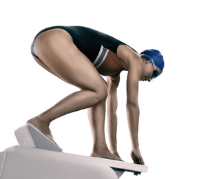 Young athletic woman preparing for jump from swimming starting block on white background