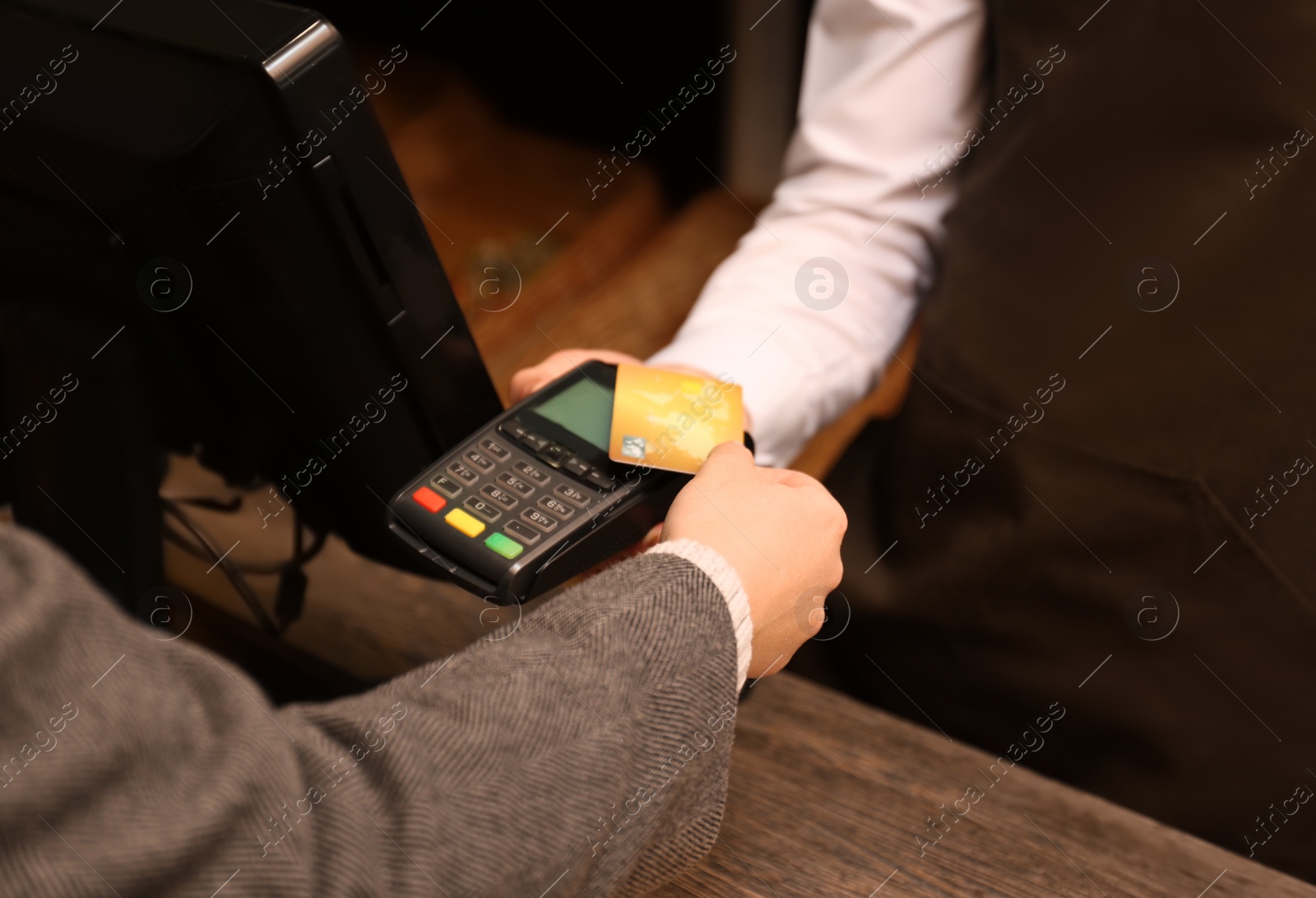 Photo of Woman with credit card using payment terminal at shop, closeup