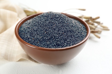 Poppy seeds in bowl on white table