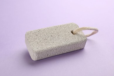 Pumice stone on violet background. Pedicure tool