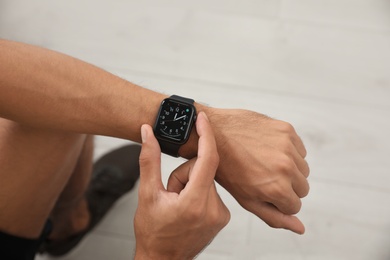 Image of MYKOLAIV, UKRAINE - OCTOBER 04, 2019: Man using Apple Watch to check time at home, closeup