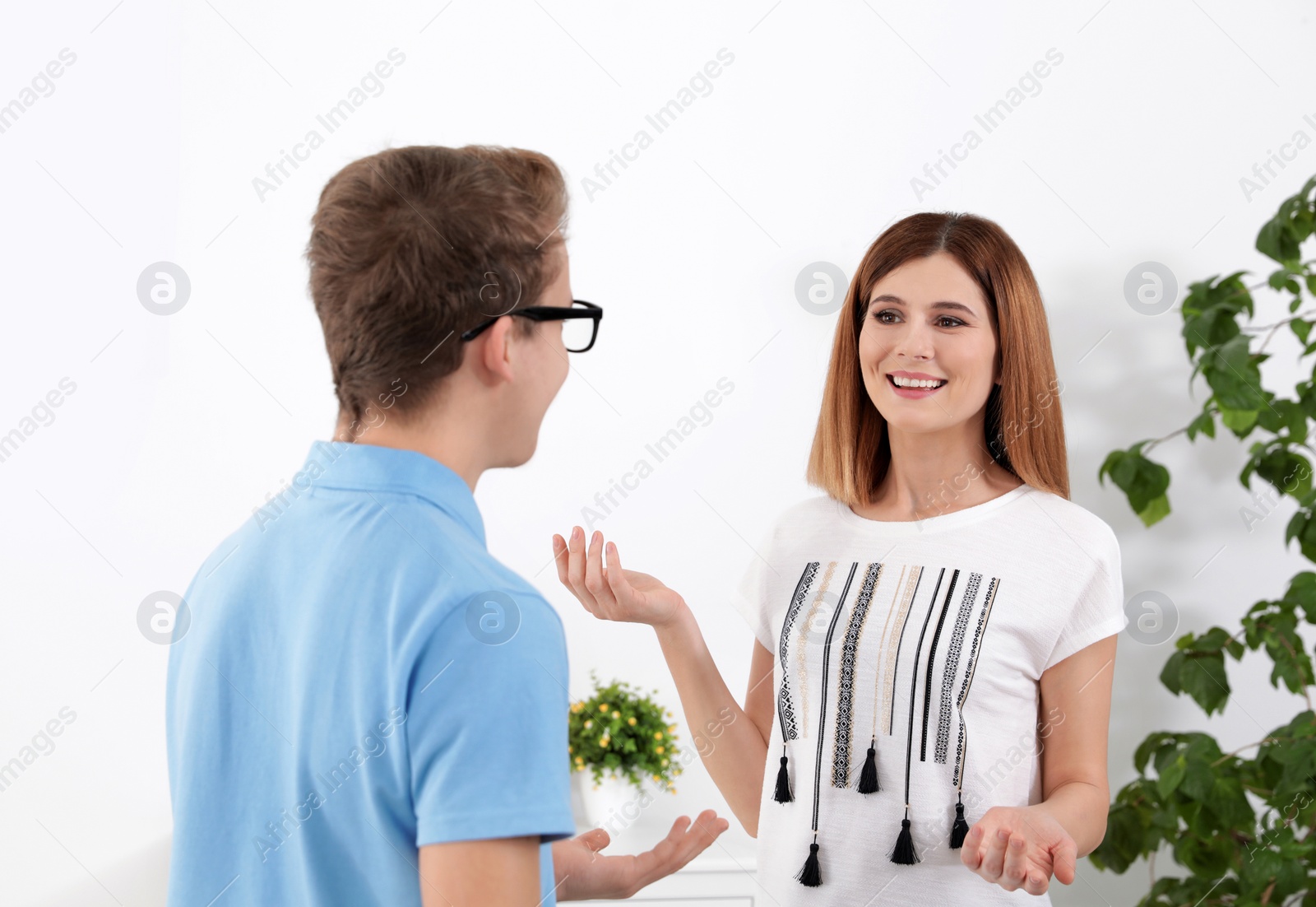 Photo of Happy mother talking with her teenager son at home