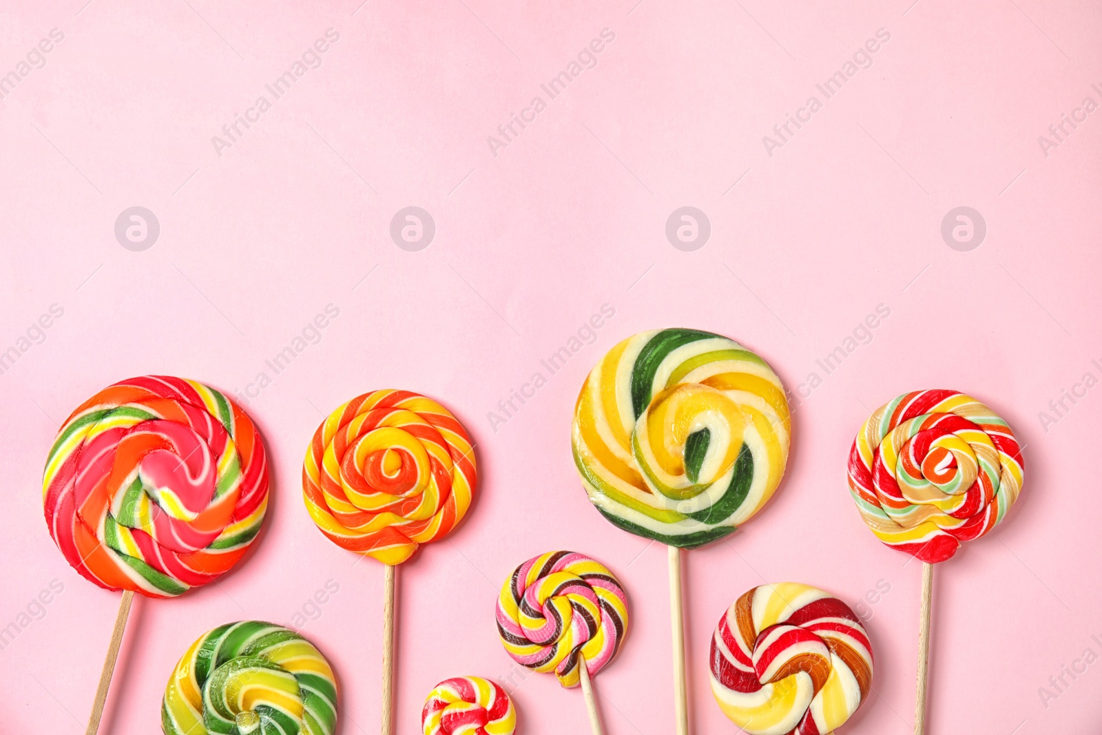 Photo of Flat lay composition with different yummy candies and space for text on color background