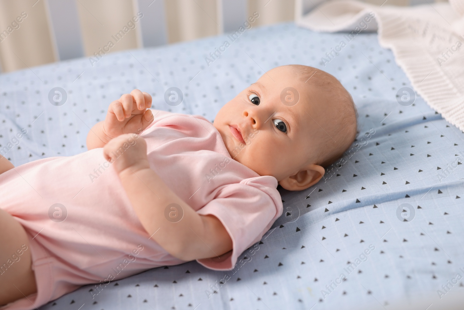 Photo of Cute little baby lying in crib at home