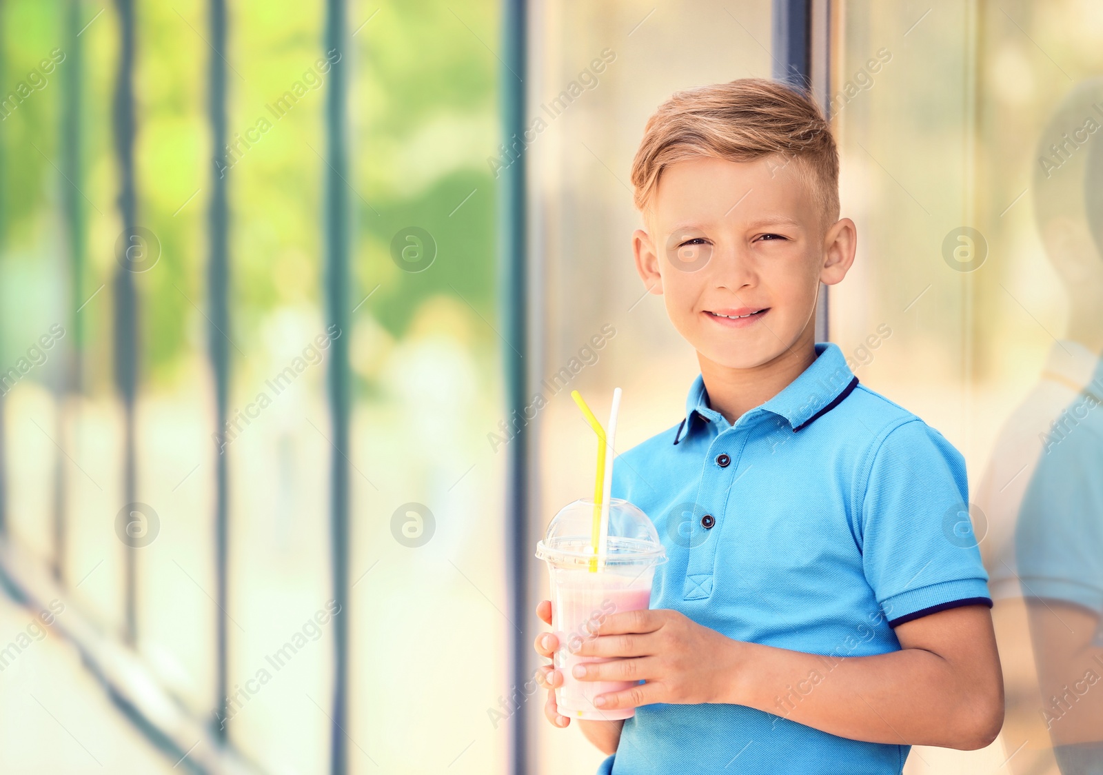 Photo of Little boy with cup of milk shake outdoors