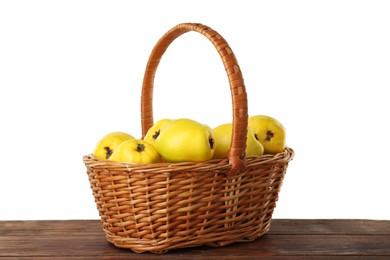 Basket with delicious fresh ripe quinces on wooden table against white background