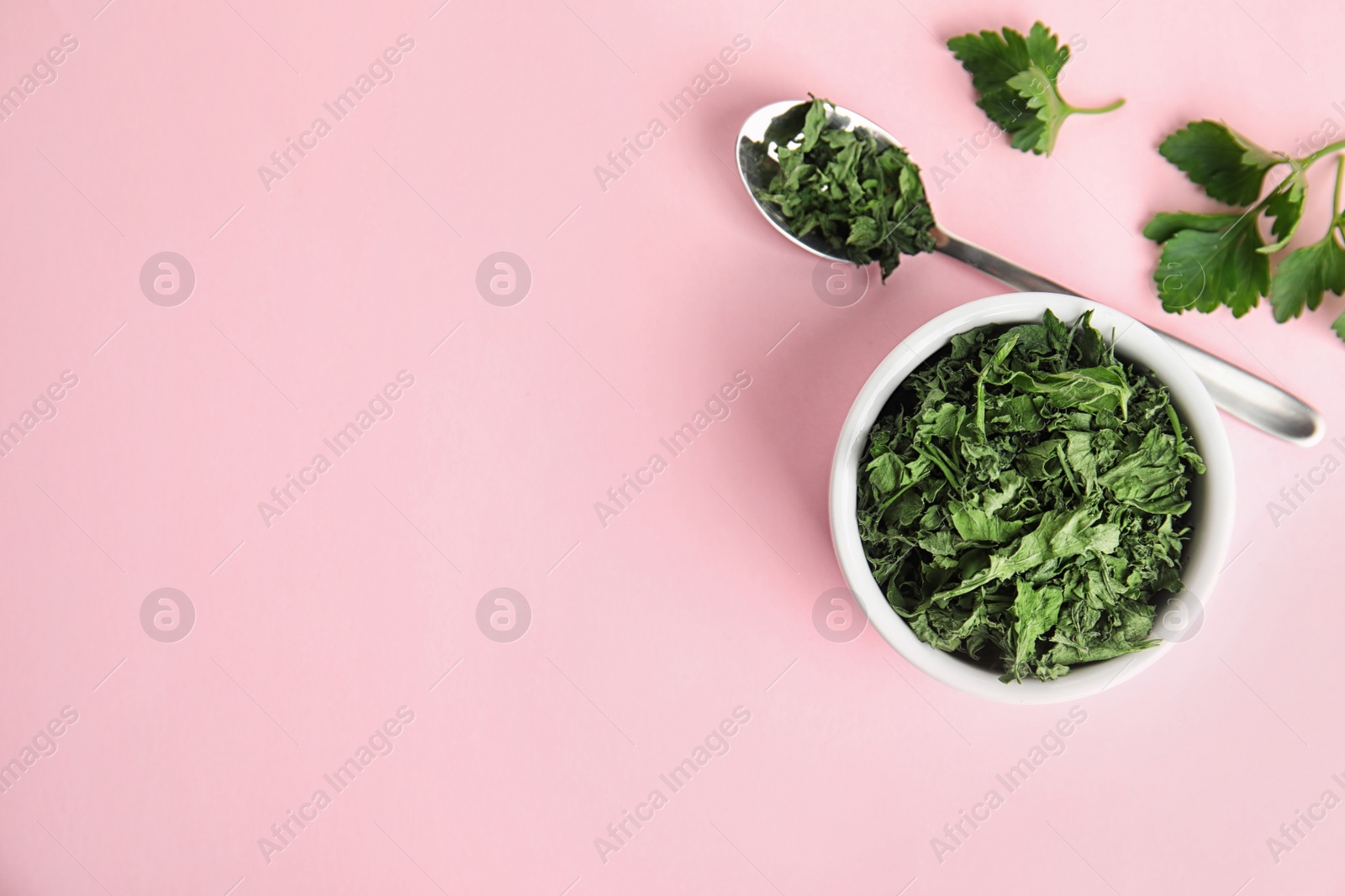 Photo of Flat lay composition with fresh and dried parsley on pink background. Space for text