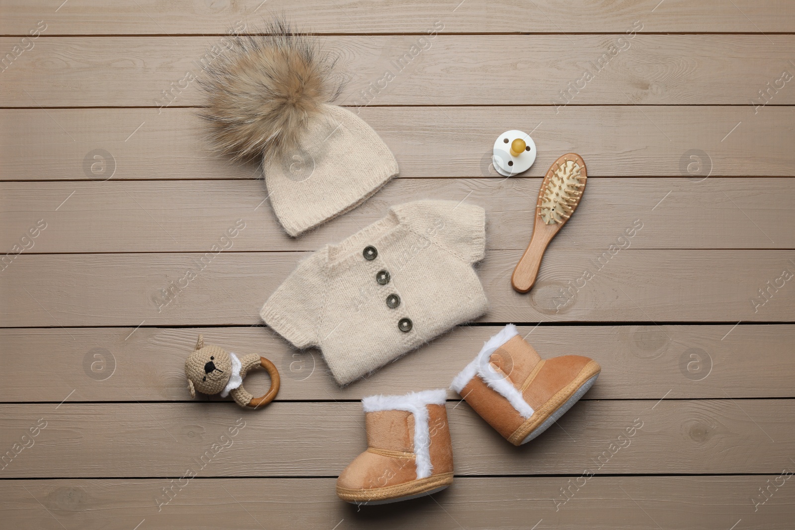 Photo of Flat lay composition with cute baby knitwear for photoshoot on wooden background