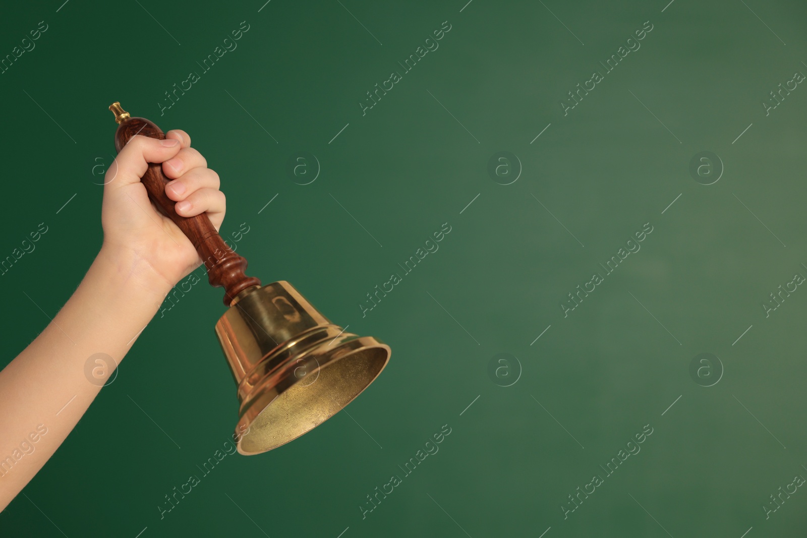 Photo of Pupil with school bell near chalkboard, closeup. Space for text