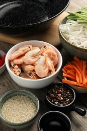Different products for cooking wok on wooden table, closeup