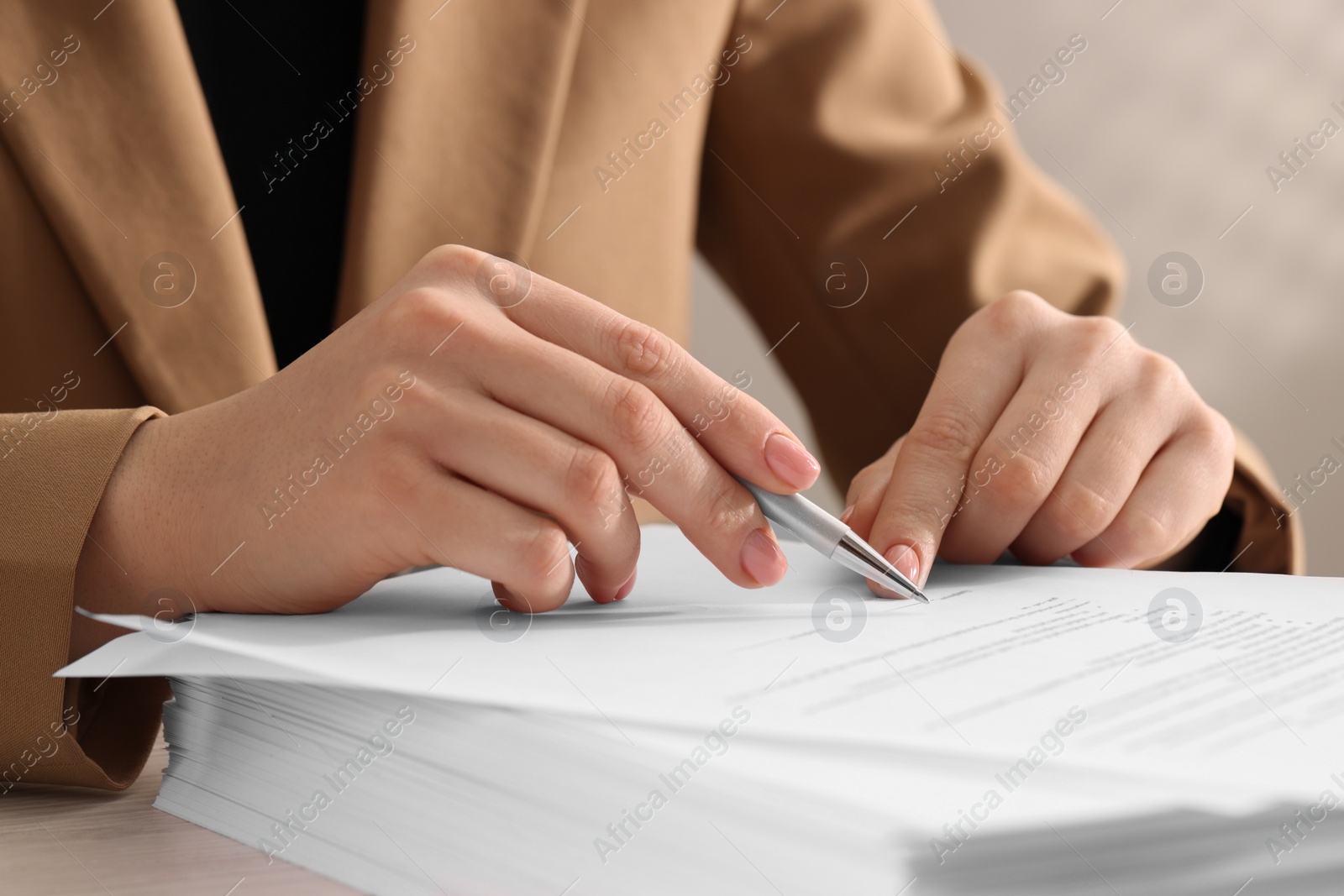 Photo of Woman signing document at table, closeup view