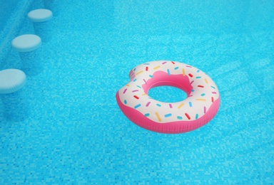 Inflatable ring floating on water in swimming pool