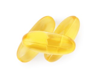 Photo of Yellow vitamin capsules isolated on white, top view