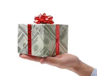 Photo of Man holding gift box wrapped in decorative paper with dollar pattern on white background, closeup