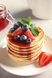 Photo of Plate with pancakes and berries on table