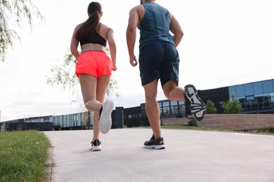 Healthy lifestyle. Couple running outdoors, low angle view