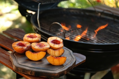 Delicious grilled peaches on wooden table outdoors