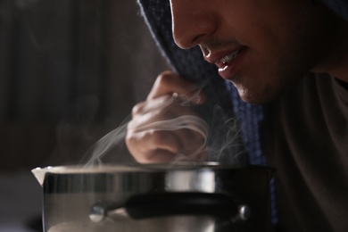 Photo of Man with plaid doing inhalation above saucepot, closeup