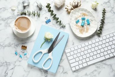 Flat lay composition with scissors, coffee and keyboard on white marble table