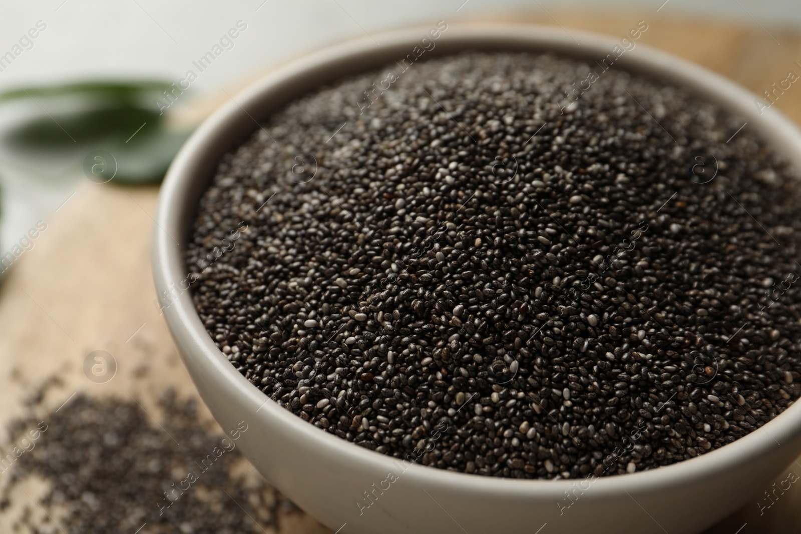 Photo of Chia seeds in bowl on table, closeup