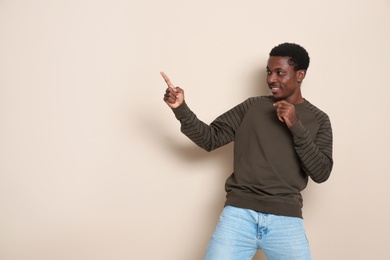 Photo of Portrait of emotional African-American man on color background. Space for text