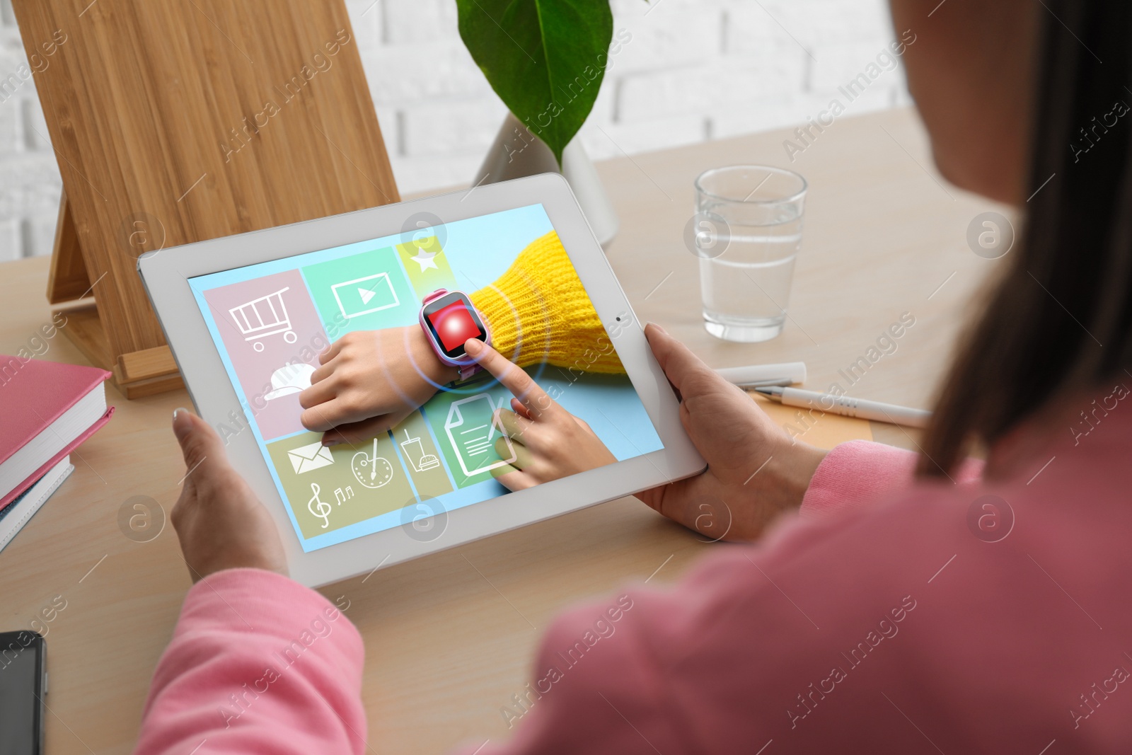 Image of Control kid's geolocation via smart watch. Woman using tablet at table, closeup
