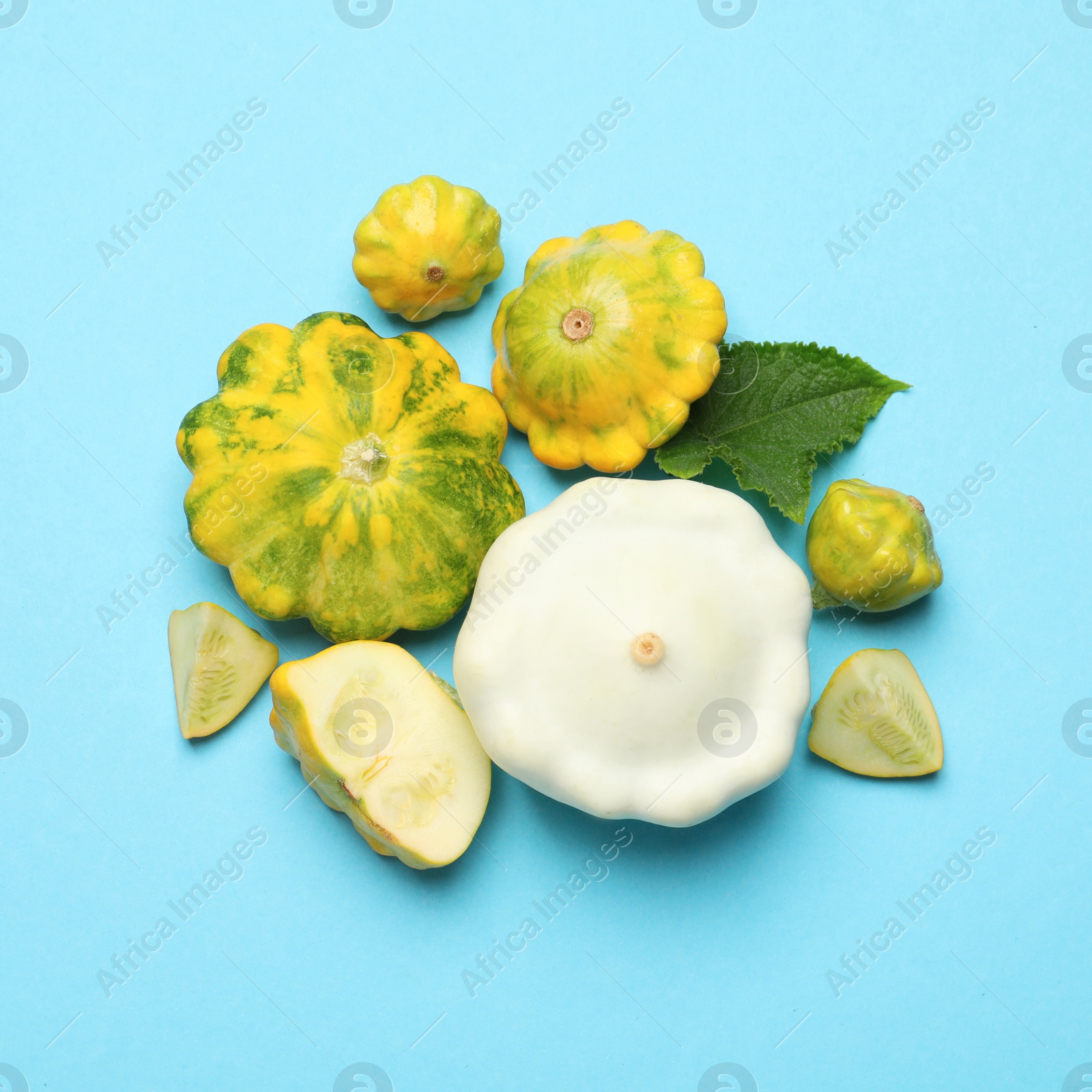 Photo of Fresh ripe pattypan squashes on light blue background, flat lay