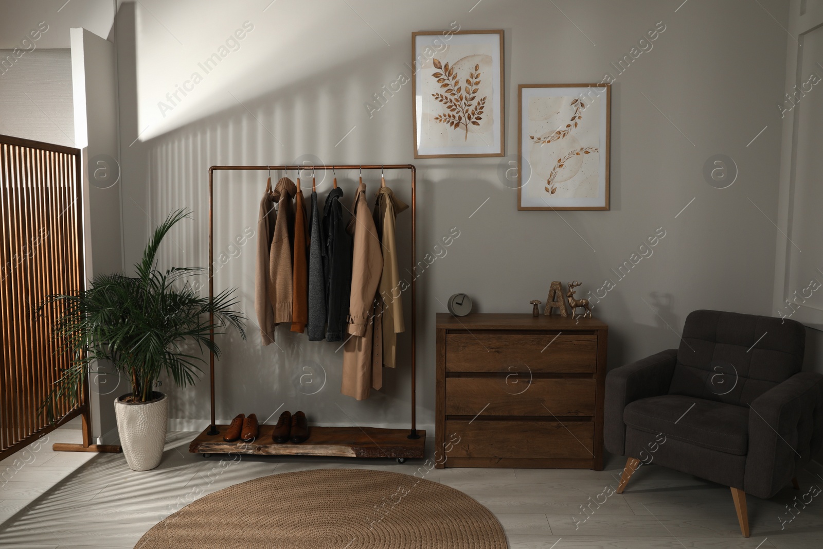 Photo of Modern dressing room interior with stylish clothes, shoes and decorative elements