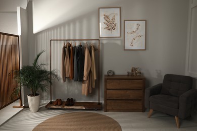 Photo of Modern dressing room interior with stylish clothes, shoes and decorative elements
