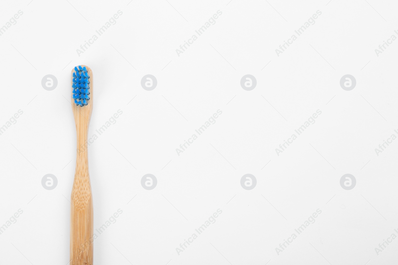 Photo of Bamboo toothbrush with blue bristle isolated on white, top view