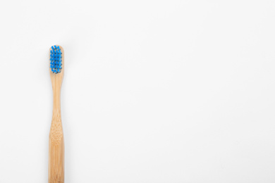 Photo of Bamboo toothbrush with blue bristle isolated on white, top view