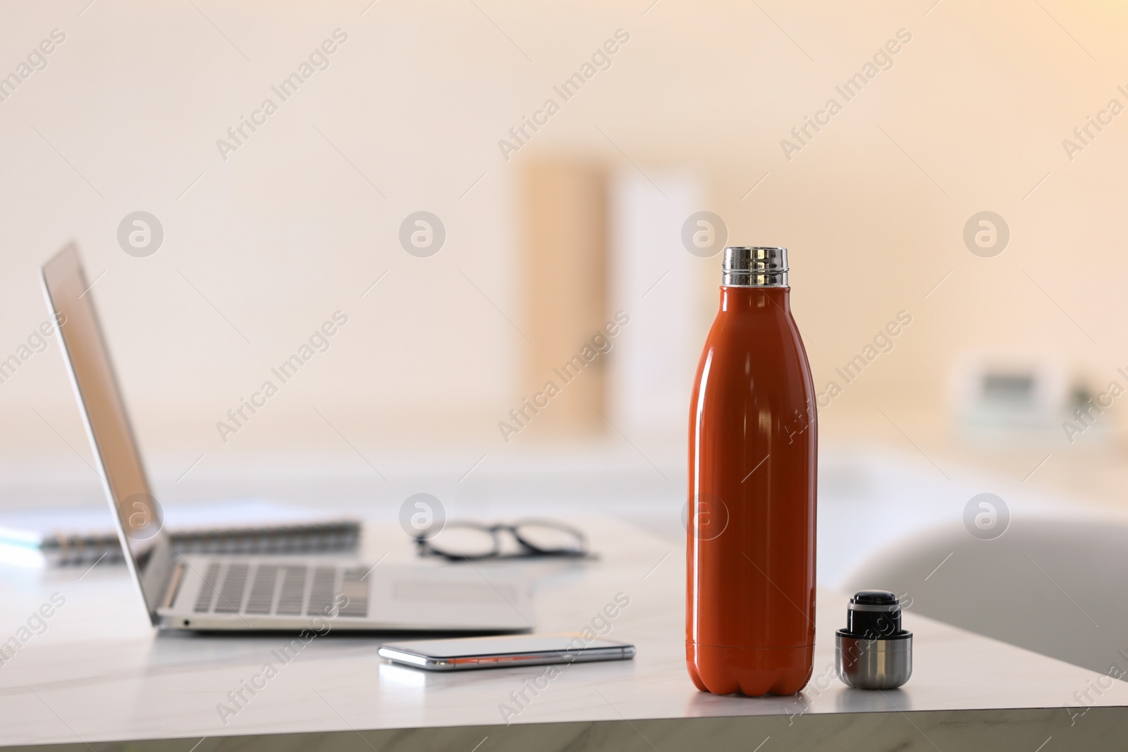 Photo of Thermo bottle on table in modern office
