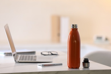 Thermo bottle on table in modern office