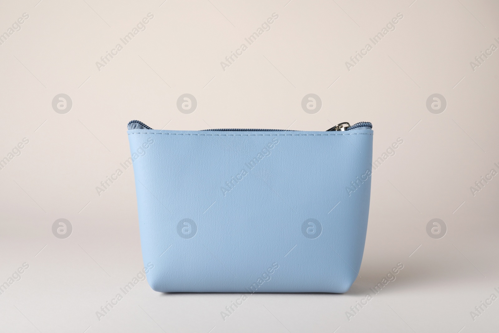 Photo of Light blue cosmetic bag on beige background