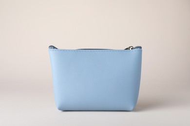 Light blue cosmetic bag on beige background