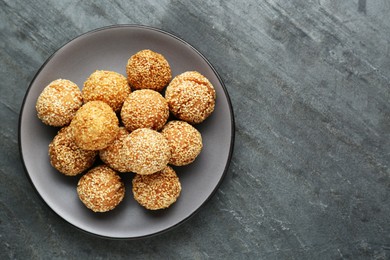Delicious sesame balls on grey table, top view. Space for text