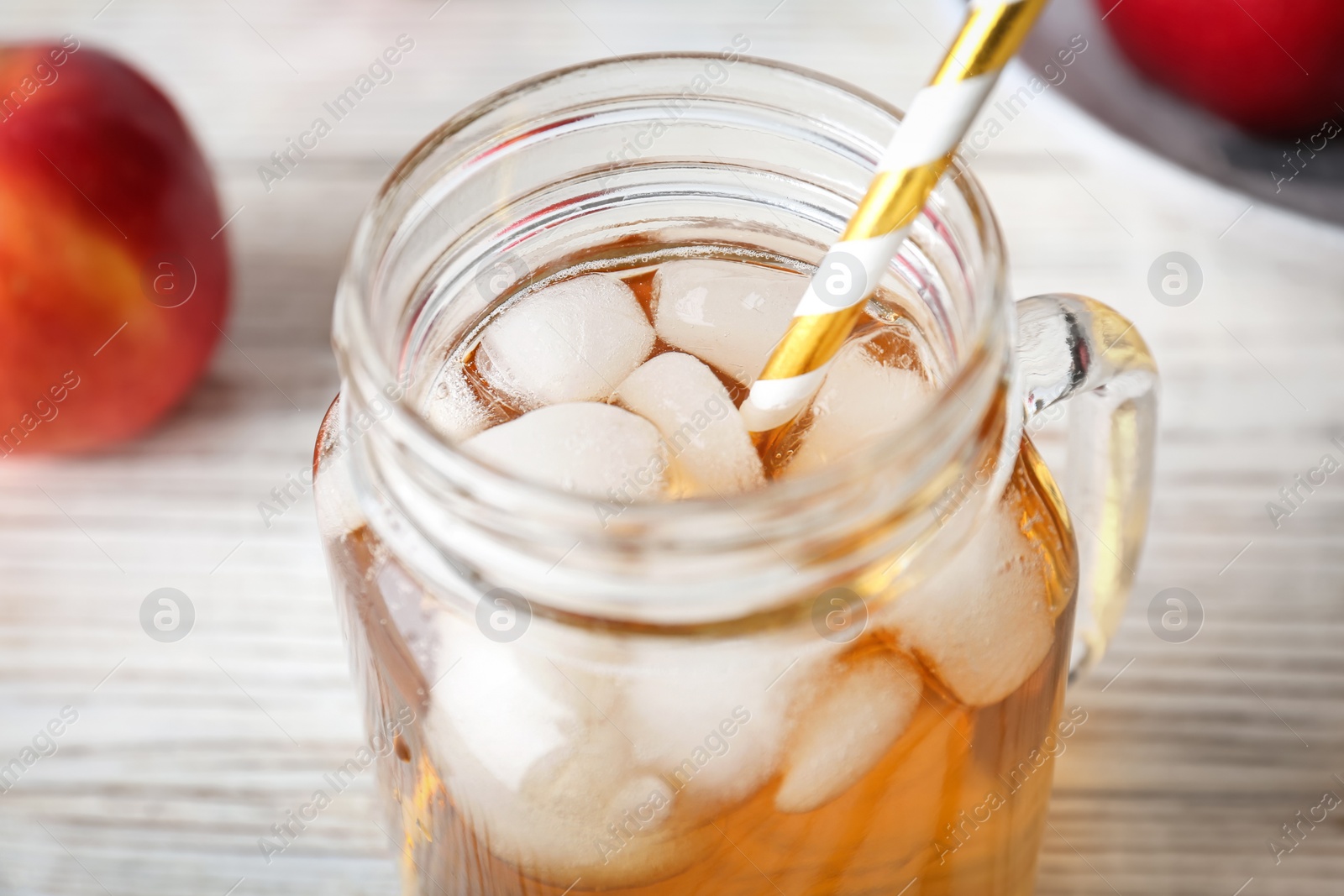 Photo of Mason jar with fresh apple juice on wooden table, closeup