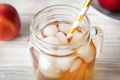 Mason jar with fresh apple juice on wooden table, closeup