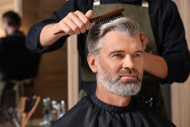 Photo of Hair styling. Professional hairdresser working with client in barbershop, closeup