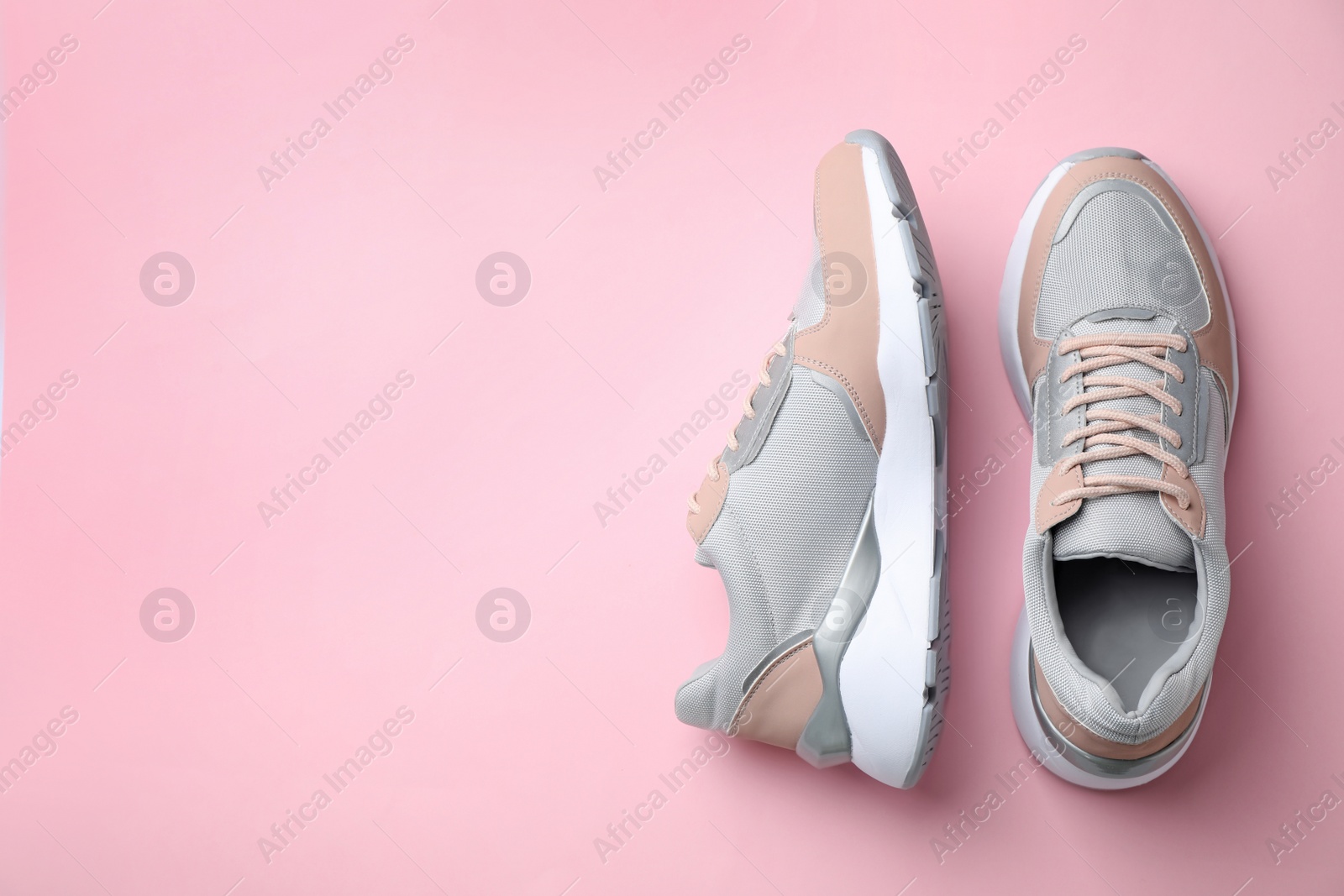 Photo of Pair of stylish sneakers on color background, top view. Space for text