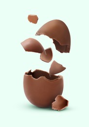 Image of Exploded milk chocolate egg on pale light blue background