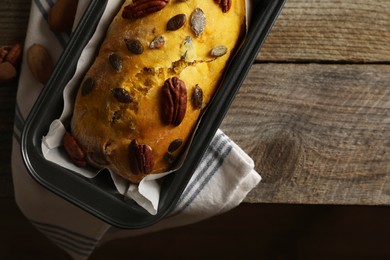 Delicious pumpkin bread with pecan nuts on wooden table, flat lay. Space for text