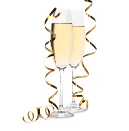 Glasses of champagne and streamers on white background