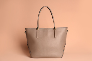 Photo of Stylish elegant woman's bag on pale pink background