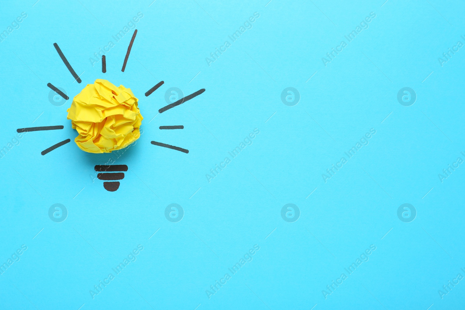 Photo of Creative composition with paper ball as lightbulb on light blue background, space for text. Idea concept
