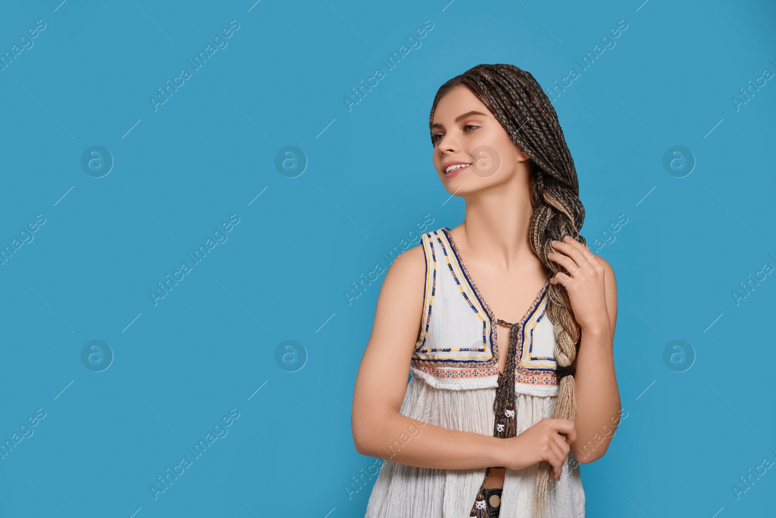 Photo of Beautiful woman with long african braids on blue background, space for text