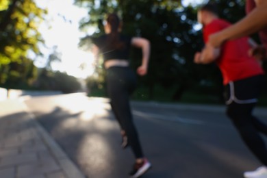 Blurred view of people running outdoors on sunny day