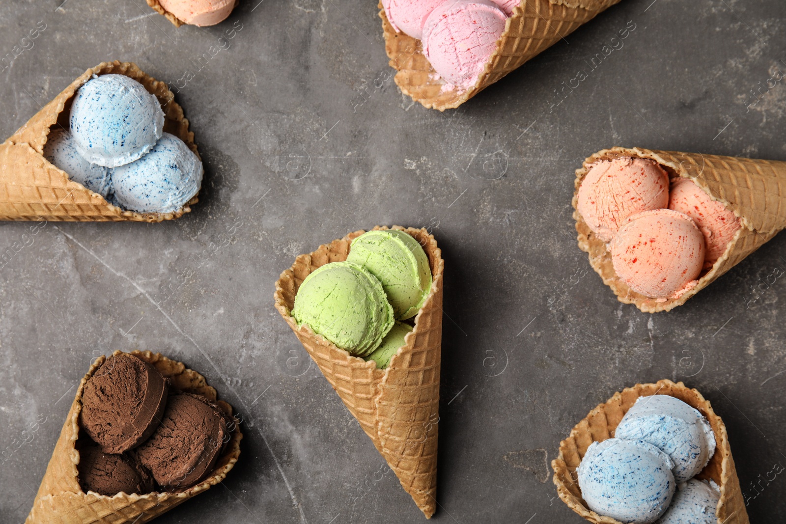 Photo of Flat lay composition with delicious ice creams in waffle cones on table