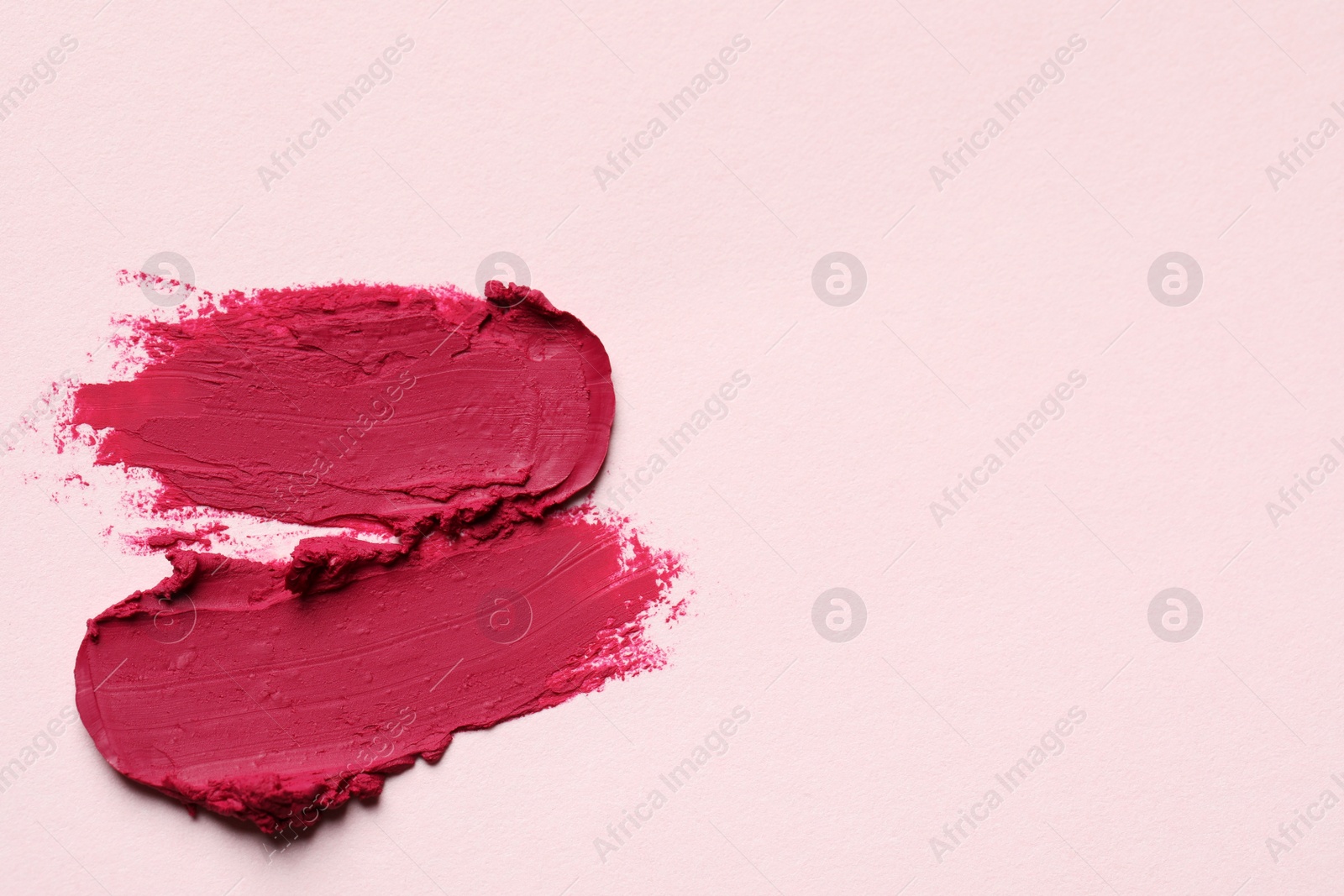 Photo of Smears of bright lipstick on light background, top view. Space for text