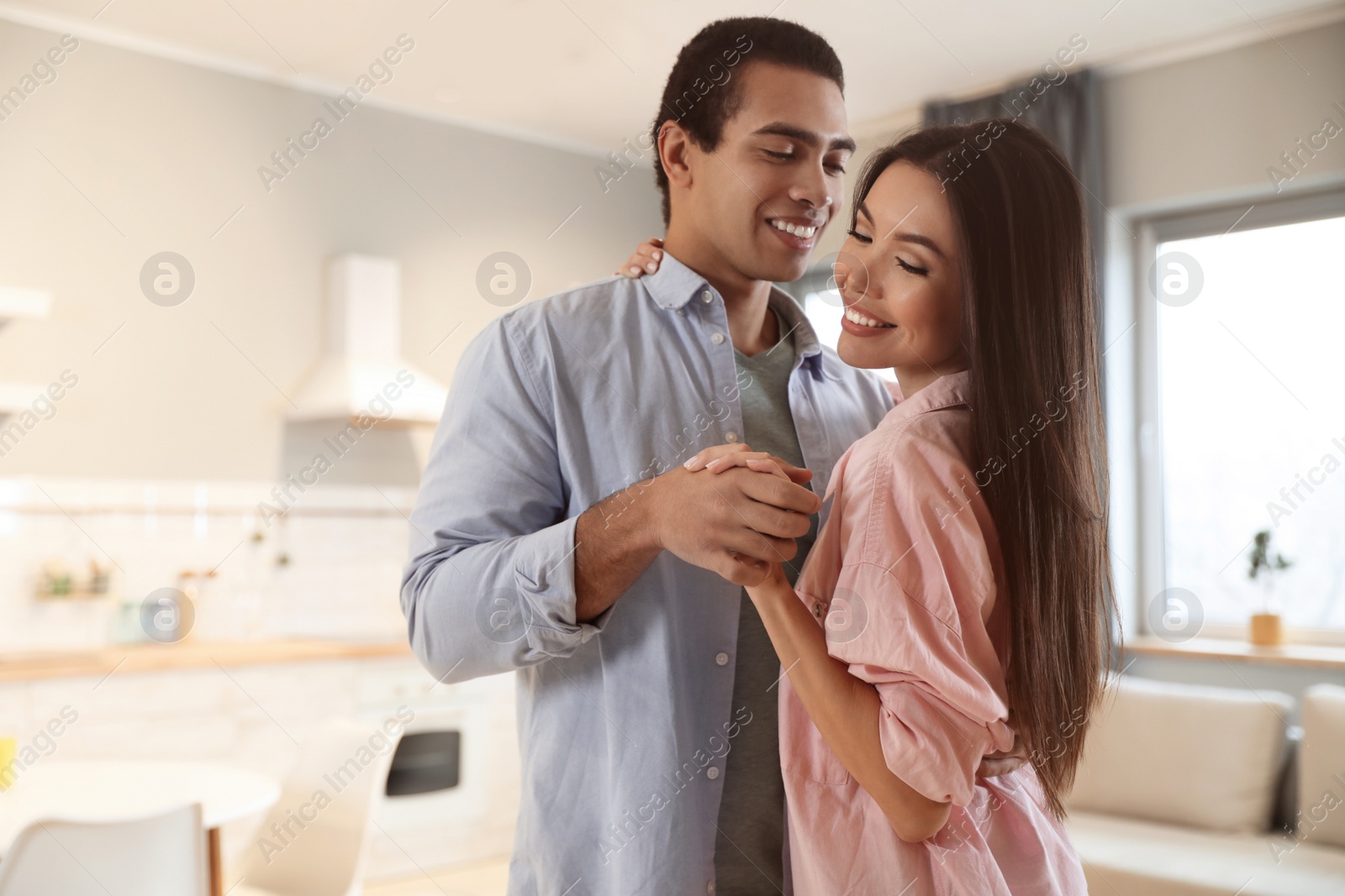 Photo of Lovely young interracial couple dancing at home